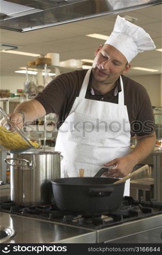Italian chef adding the pasta to the boiling water