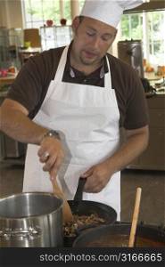 Italian chef stirring the mushrooms on the stove