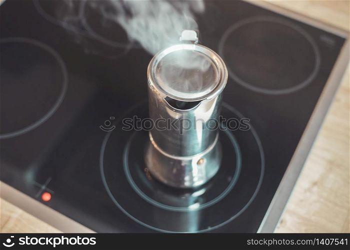 Italian coffee cooker on hot stove, breakfast