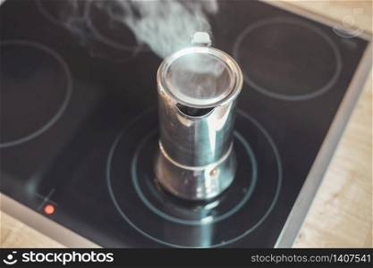 Italian coffee cooker on hot stove, breakfast
