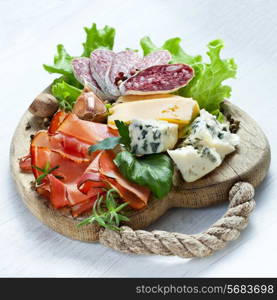 Italian cuisine. Prosciutto, cheese, salami, herbs.