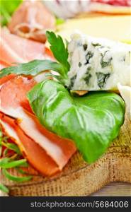 Italian cuisine. Prosciutto, cheese, salami, herbs.