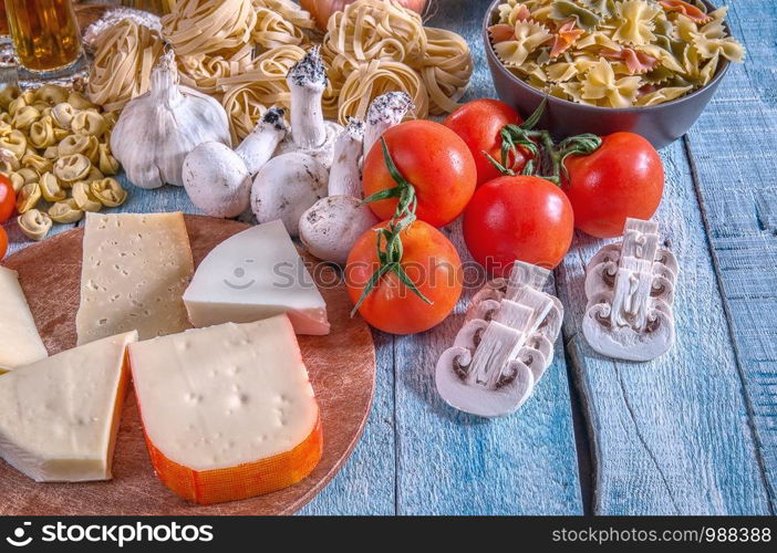 Italian cuisine with a set of ingredients for cooking pasta on a wooden surface.