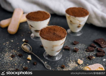 Italian dessert tiramisu in glass and eclairs with chocolate slices