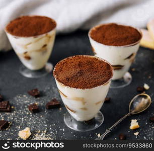 Italian dessert tiramisu in glass and eclairs with chocolate slices