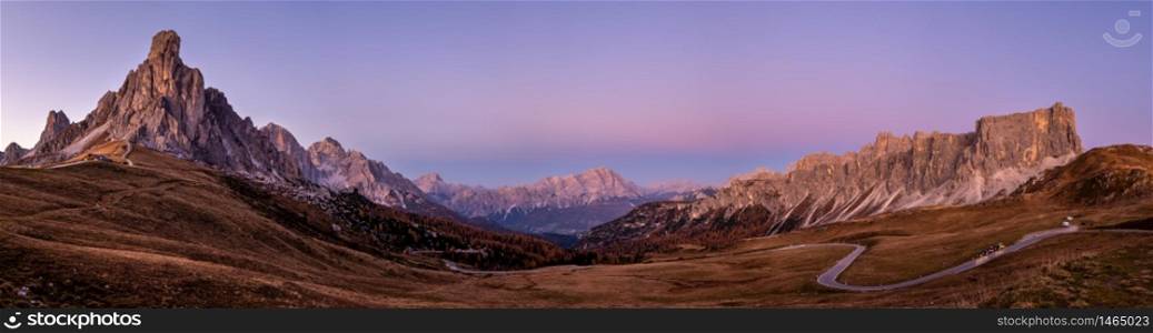 Italian Dolomites mountain (Ra Gusela rock in front) peaceful evening dusk panorama from Giau Pass. Picturesque climate, environment and weather concept sky background. Car models unrecognizable.