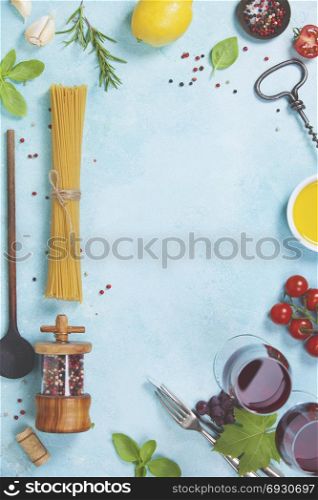 Italian food background. Mozzarella cheese, fresh basil leaves, tomatoes, olive oil, spaghetti and glasses of red wine on concrete background, top view. Caprese salat ingredients