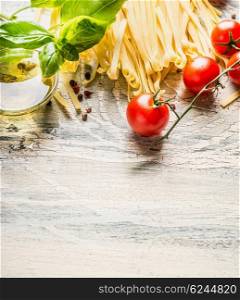 Italian food background with pasta, tomatoes, basil and olive oil on light rustic background, place for text