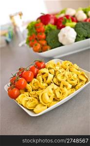 Italian food - pasta, tomato, ingredients for cooking in kitchen