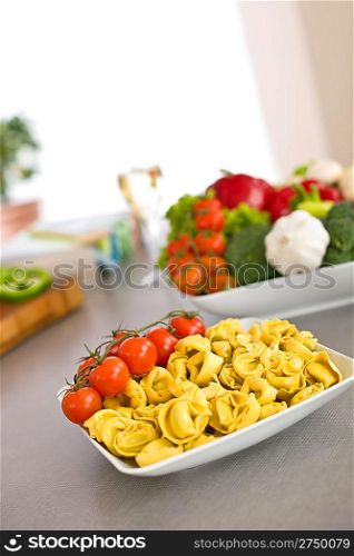 Italian food - pasta, tomato, ingredients for cooking in kitchen