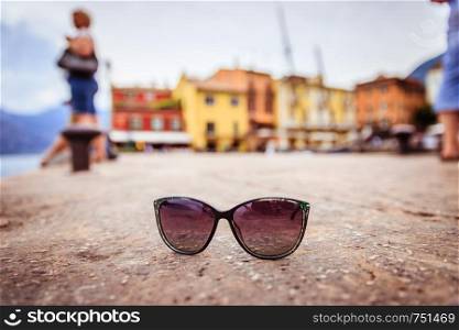 Italian harbour scene: Sunglasses on the stony ground