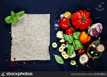 Italian ingredients - pasta, vegetables, spices, cheese - on dark background