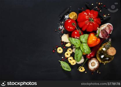 Italian ingredients - pasta, vegetables, spices, cheese - on dark background