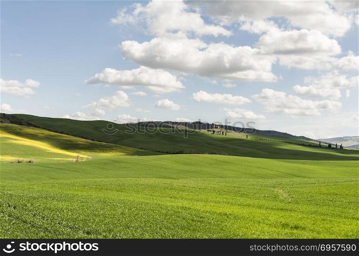 Italian landscape with meadows early in the spring. Agriculture in Italy, fields, pastures and farmhouses on the hill.. Fields, pastures and farmhouse