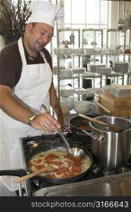 Italian man cooking pasta in the restaurant kitchen