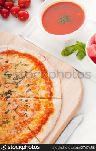 Italian original thin crust pizza Margherita with gazpacho soup and watermelon on side,and vegetables on background