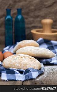 Italian panini rolls in rustic kitchen setting with cooking utensils