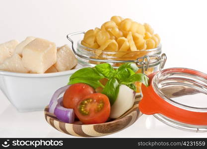 Italian pasta and ingredients for dressing on a white background