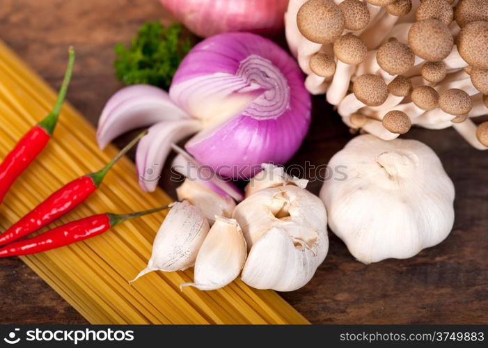 Italian pasta and mushroom sauce raw ingredients over rustic old wood