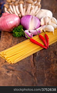 Italian pasta and mushroom sauce raw ingredients over rustic old wood