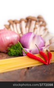 Italian pasta and mushroom sauce raw ingredients over rustic old wood