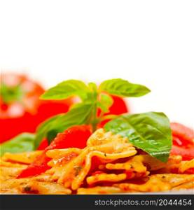 Italian pasta farfalle butterfly bow-tie with tomato basil sauce over white rustic wood table