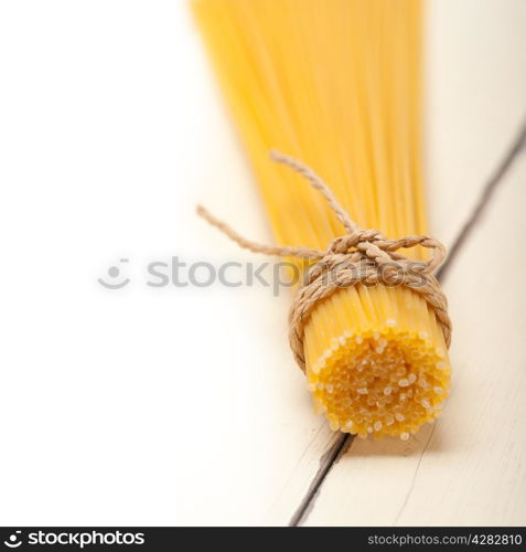 Italian pasta spaghetti tied with a rope on a rustic table