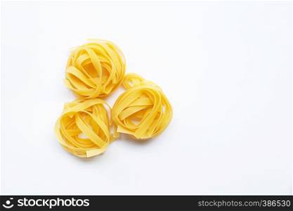 Italian pasta tagliatelle nest on white background. Copy space