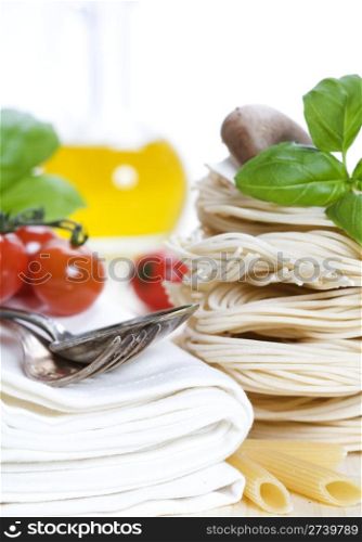 Italian Pasta with tomatoes, mushrooms, olive oil and basil on a white background