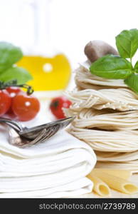 Italian Pasta with tomatoes, mushrooms, olive oil and basil on a white background