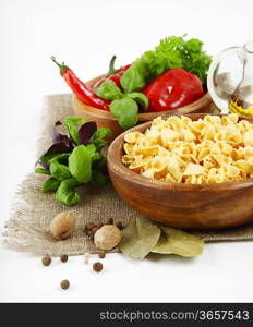 Italian Pasta with vegetables in wooden plate isolated on white.