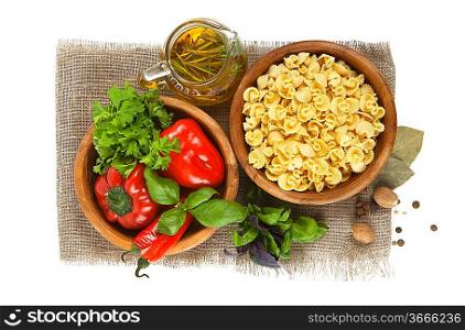 Italian Pasta with vegetables in wooden plate isolated on white.