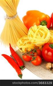 Italian Pasta with vegetables in wooden plate isolated on white.