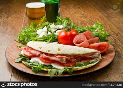 italian piadina with ham, fresh salad and mozzarella cheese