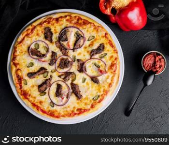 italian pizza with tomatoes, cheese, onions on black