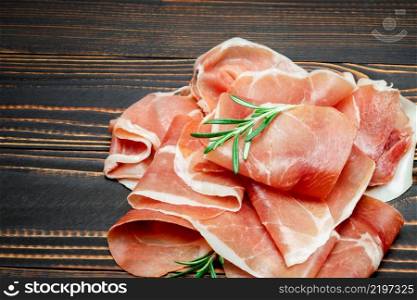 Italian prosciutto crudo or spanish jamon. Raw ham on wooden background or table. Italian prosciutto crudo or spanish jamon. Raw ham on wooden background