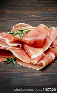 Italian prosciutto crudo or spanish jamon. Raw ham on wooden background or table. Italian prosciutto crudo or spanish jamon. Raw ham on wooden background