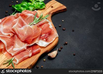 Italian prosciutto crudo or spanish jamon. Raw ham on wooden cutting board. concrete background. Italian prosciutto crudo or spanish jamon. Raw ham on wooden cutting board