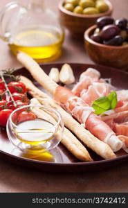 italian prosciutto ham grissini bread sticks tomato olive oil