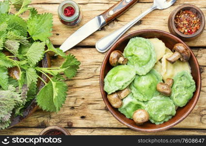 Italian ravioli stuffed with greens in a plate on a wooden vintage table.. Homemade ravioli stuffed with nettle