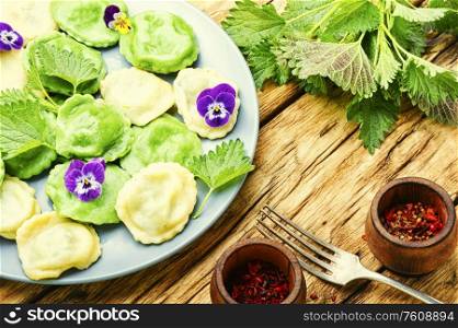 Italian ravioli stuffed with greens in a plate on a wooden vintage table.. Plate of ravioli with herb
