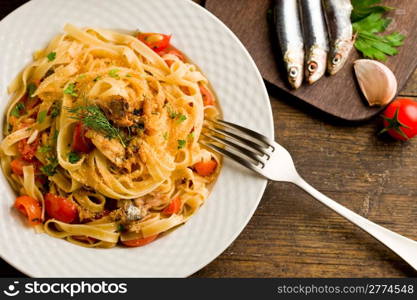 Italian regional dish made of pasta with sardines on wooden table