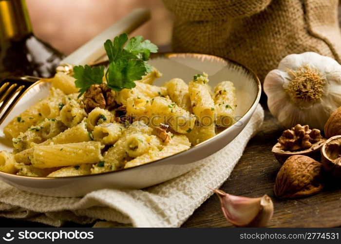 Italian regional dish made of pasta with walnut pesto on wooden table