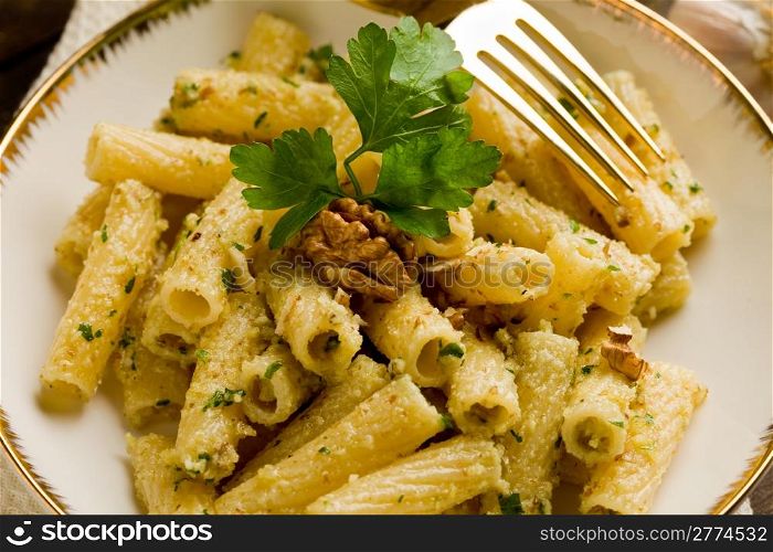 Italian regional dish made of pasta with walnut pesto on wooden table