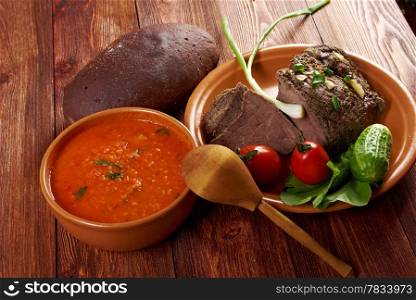 Italian rustic dinner - tomato soup or Pappa al Pomodoro and roasted beef and vegetables with bread ,farm-style