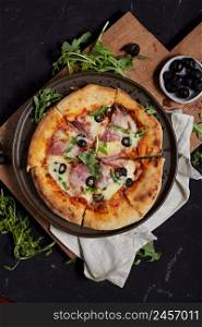 Italian salami pizza with mozzarella and fresh herbs served on plate.. Italian salami pizza with mozzarella