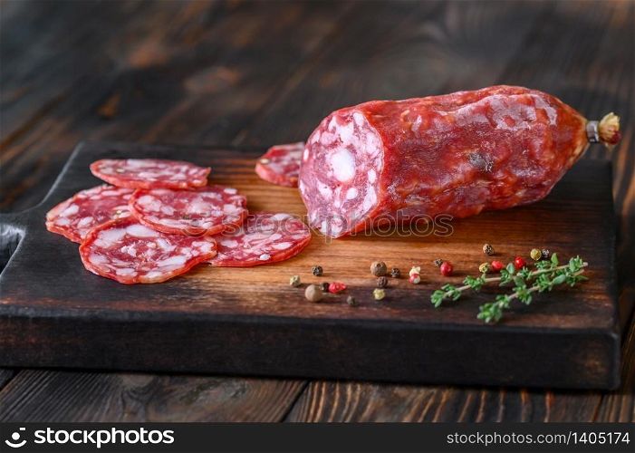 Italian salami with fresh thyme on the wooden board