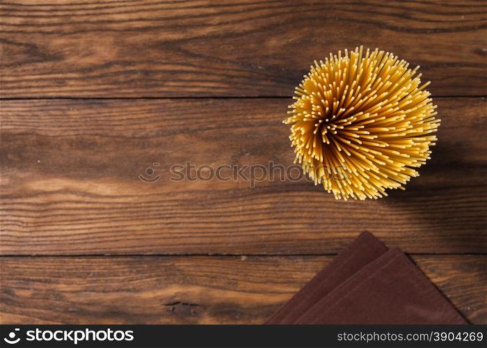 italian spaghetti and napkin on wooden background. Top view. italian spaghetti and napkin on wooden background