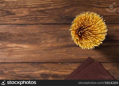 italian spaghetti and napkin on wooden background. Top view. italian spaghetti and napkin on wooden background