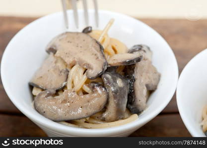 Italian spaghetti pasta and fresh wild mushrooms on rustic wood table